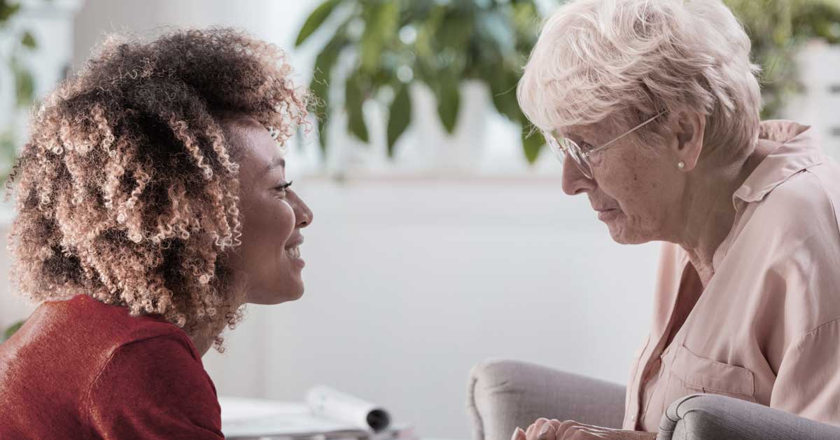 A social worker talking with an elderly patient